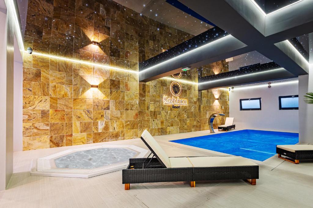 a swimming pool in a room with a large wall of tiles at Kashubian Resort in Władysławowo