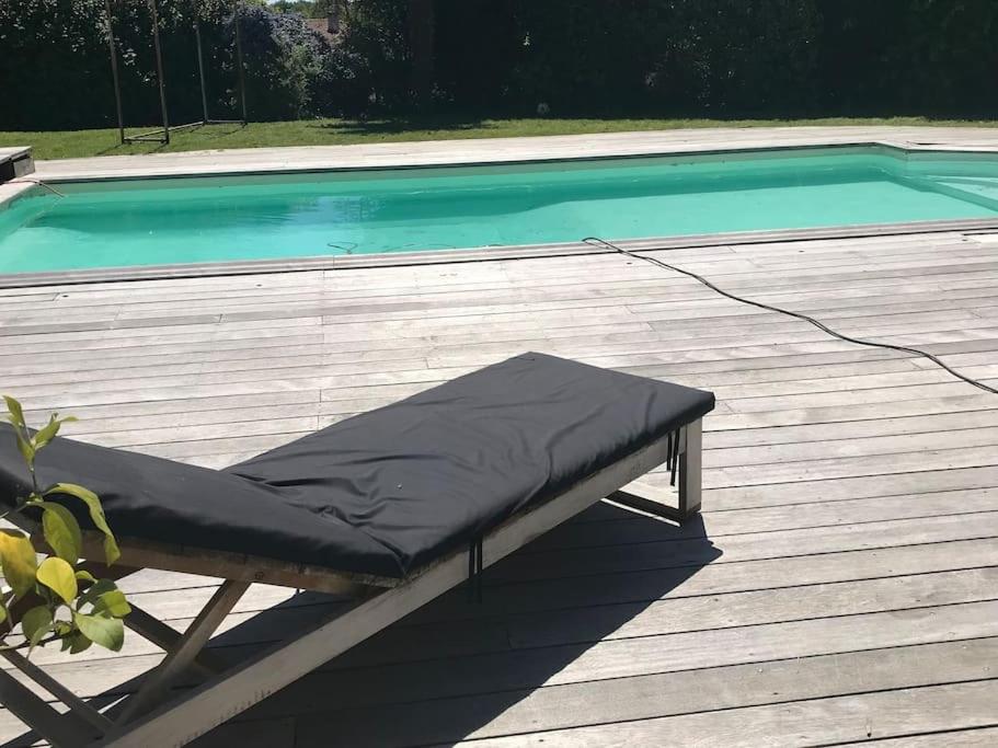 - un lit installé sur une terrasse à côté d'une piscine dans l'établissement Villa K Maison archi avec piscine 15 mn PUY du FOU, à Cholet