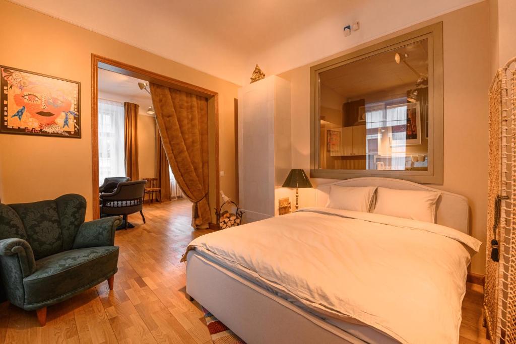 a bedroom with a bed and a chair and a mirror at St.Jacobs's apartments Old Town Riga in Rīga