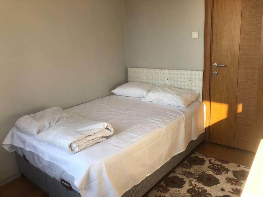 a bed with white sheets and pillows in a room at A Beachfront, Peninsula View Apartment in Karaköy in Istanbul