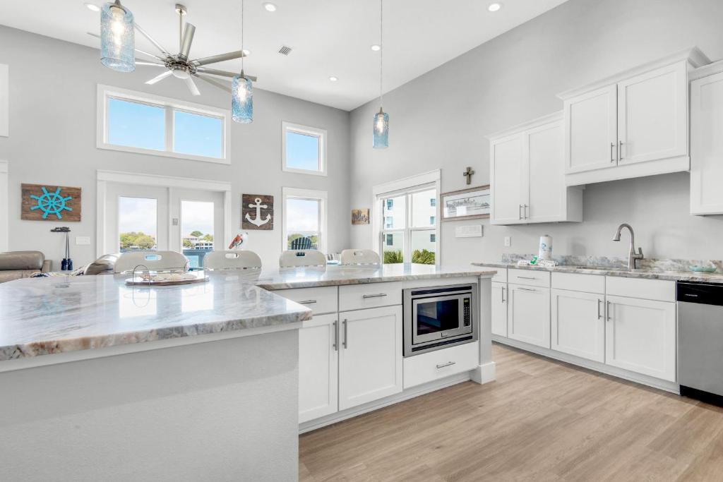 a large white kitchen with white cabinets and appliances at Pelican at Sound Side in Fort Walton Beach