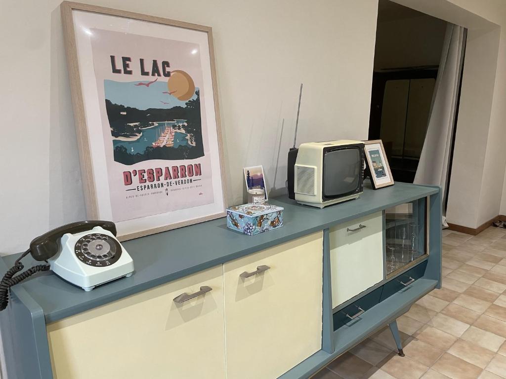 a television and a telephone sitting on top of a dresser at T3 rénové esprit vintage, au coeur du Verdon in Montagnac