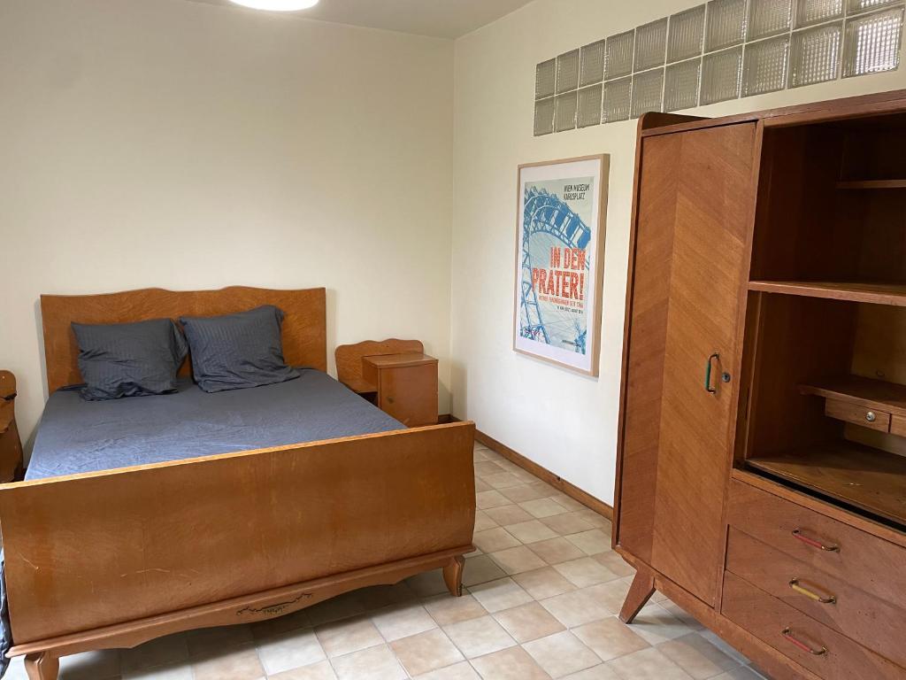 a bedroom with a bed and a wooden cabinet at T3 rénové esprit vintage, au coeur du Verdon in Montagnac