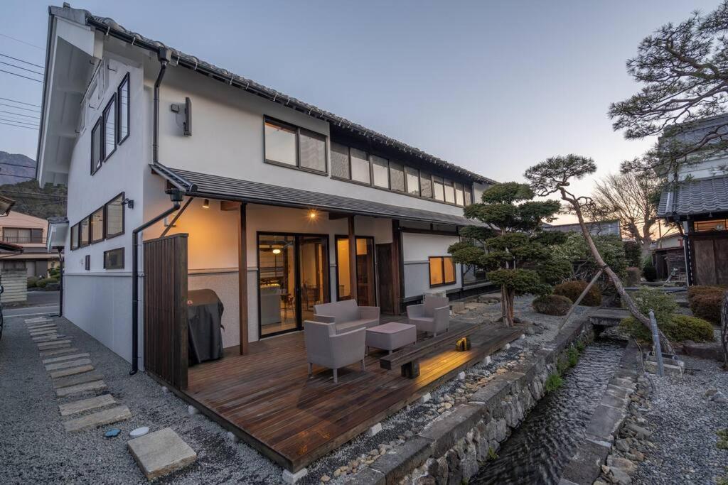 a house with a wooden deck in front of it at MITSU-House in Nishikatsuracho