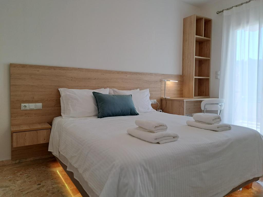 1 dormitorio con 1 cama blanca grande y toallas. en Luxury Suite Patras (1), en Patra