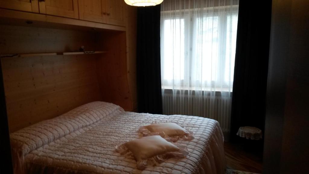 1 dormitorio con 1 cama con toallas en B&B fam. Ausermiller, en Castello di Fiemme