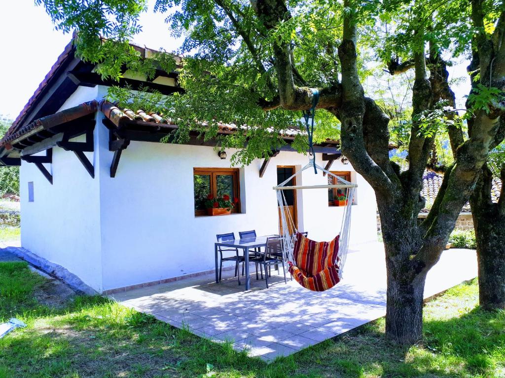 a white house with a hammock in front of it at Casa de campo entre dos parques naturales in Igorre