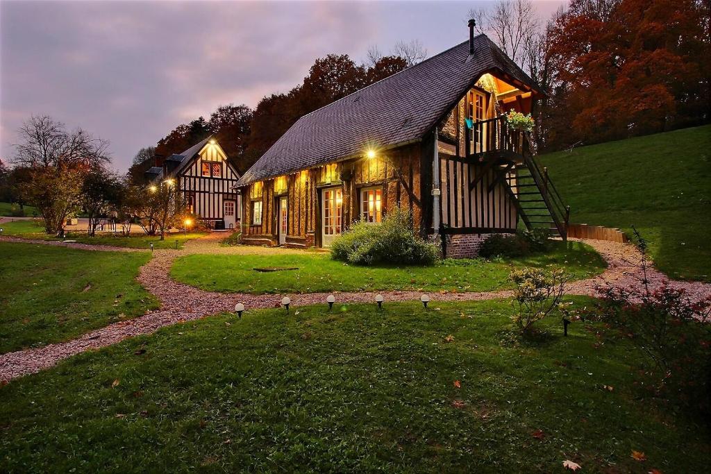 uma grande casa de madeira com luzes em Les Fermes de Florence Bien être et nature em Les Champeaux