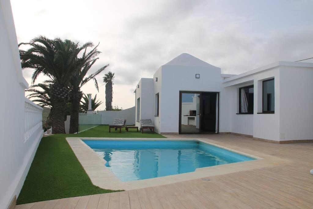 Biały dom z basenem na dziedzińcu w obiekcie Villa Darío en Nazaret w mieście Nazaret