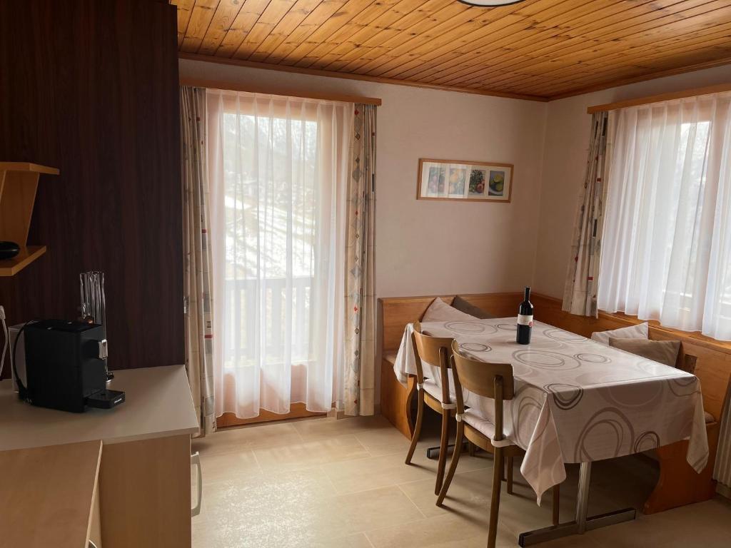 a dining room with a table and some windows at Gaby in Grächen