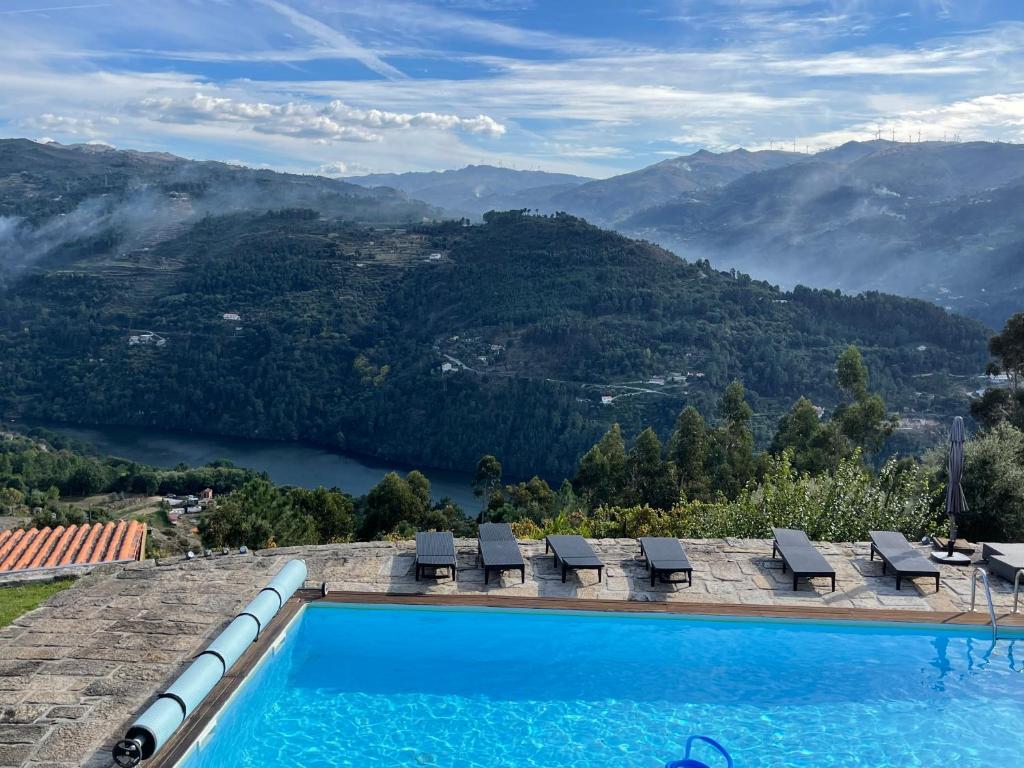 a swimming pool with chairs and a view of a mountain at Casa Catita - Douro in Baião