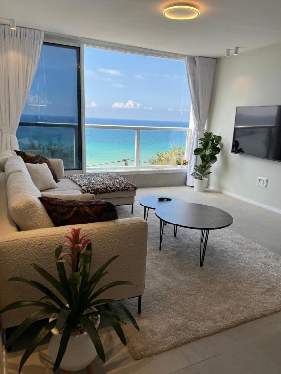 uma sala de estar com um sofá e uma mesa em Vacation Apartment By The Beach em Bat Yam