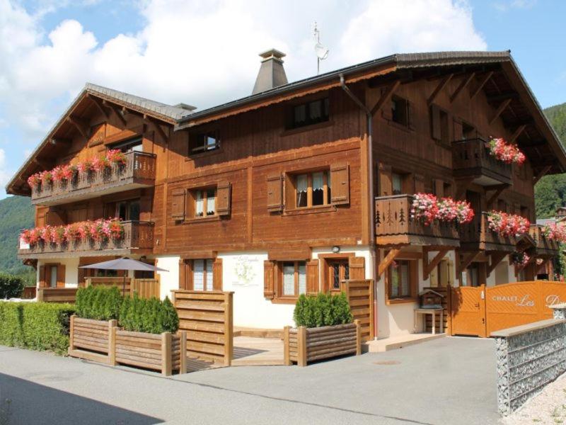 una gran casa de madera con flores delante en Savoy Morzine en Morzine