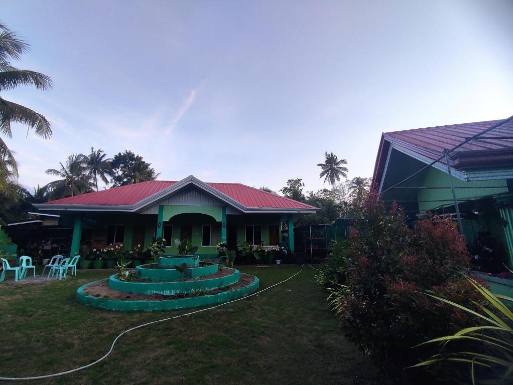 a house with a red roof and a yard at BARRIL GREEN HOMESTAY in Batuan