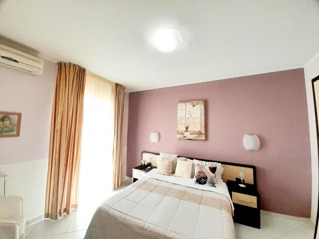 a bedroom with a bed and a purple wall at Appartamento Castel Sant'Angelo in Licata