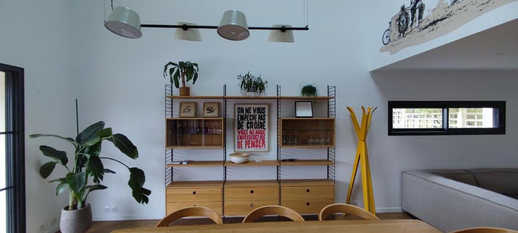 uma sala de estar com uma mesa e uma estante de livros em BARTHOME em Taissy