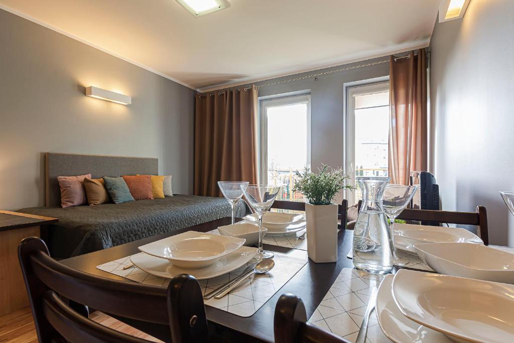 a dining room with a table and a couch at VacationClub - Bryza 7 Apartament 5 in Świnoujście