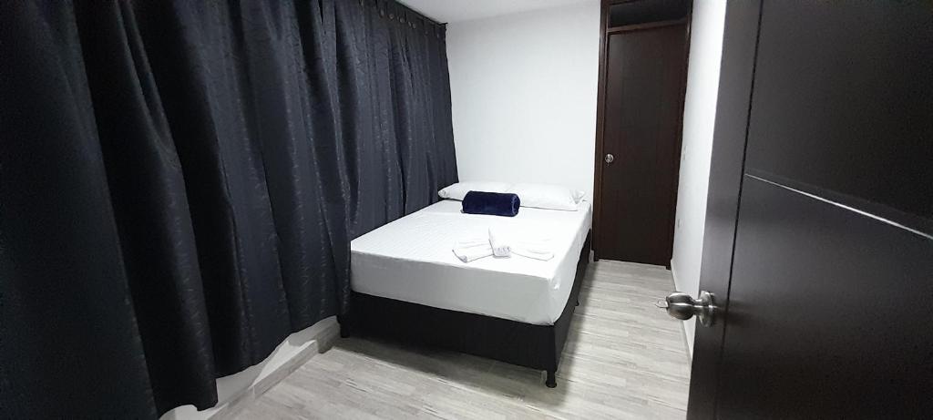 Cama pequeña en habitación con cortina negra en Hotel Caldas Real, en Caldas