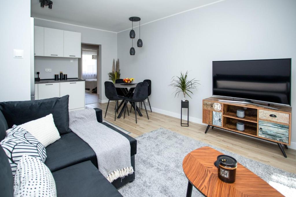 uma sala de estar com um sofá e uma televisão de ecrã plano em Apartament Sopot Kamienny Potok Kujawska em Sopot