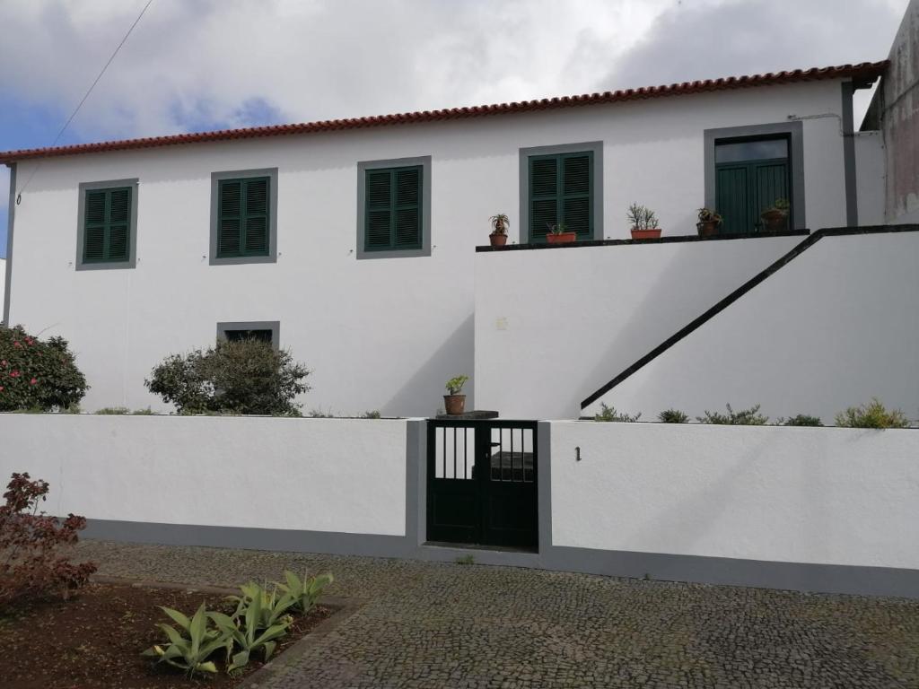 una casa blanca con una puerta negra y una valla en A Casa da Matriz, en Madalena