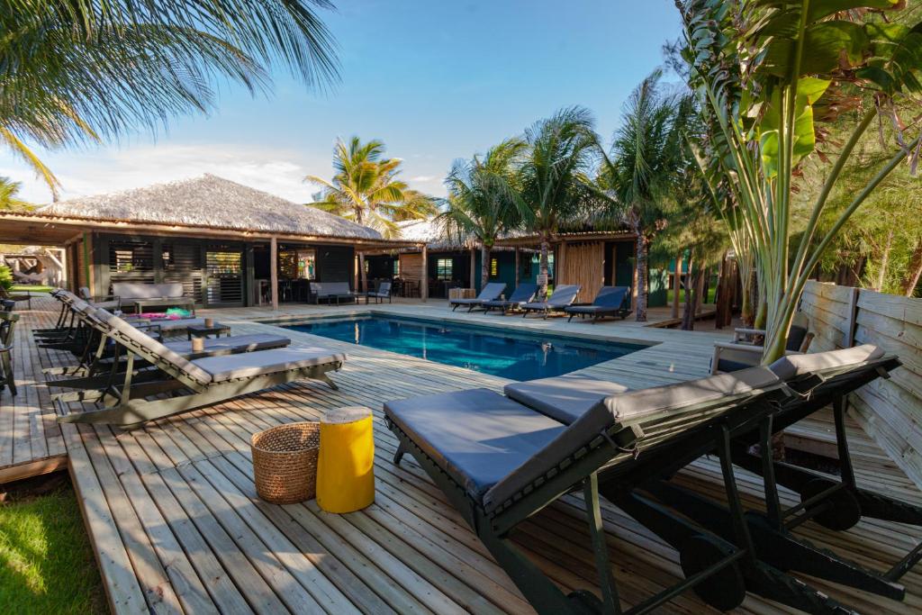 a swimming pool with chairs and a house at Hotel & Restaurante VilaVeraTheresa in Fortim