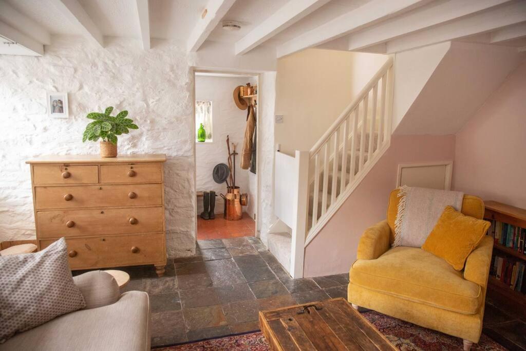 - un salon avec une chaise et un escalier dans l'établissement Family-friendly Cottage in the heart of St Columb, à Saint Columb Major