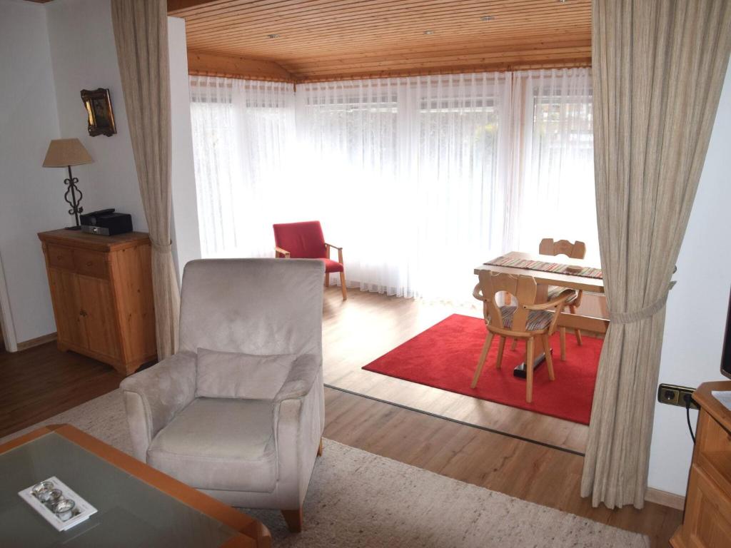 - un salon avec une chaise et un bureau dans l'établissement Vacation home Fussen, à Füssen