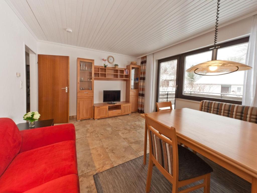 uma sala de estar com uma mesa e um sofá vermelho em Holiday home Reichenbach em Bayerstetten