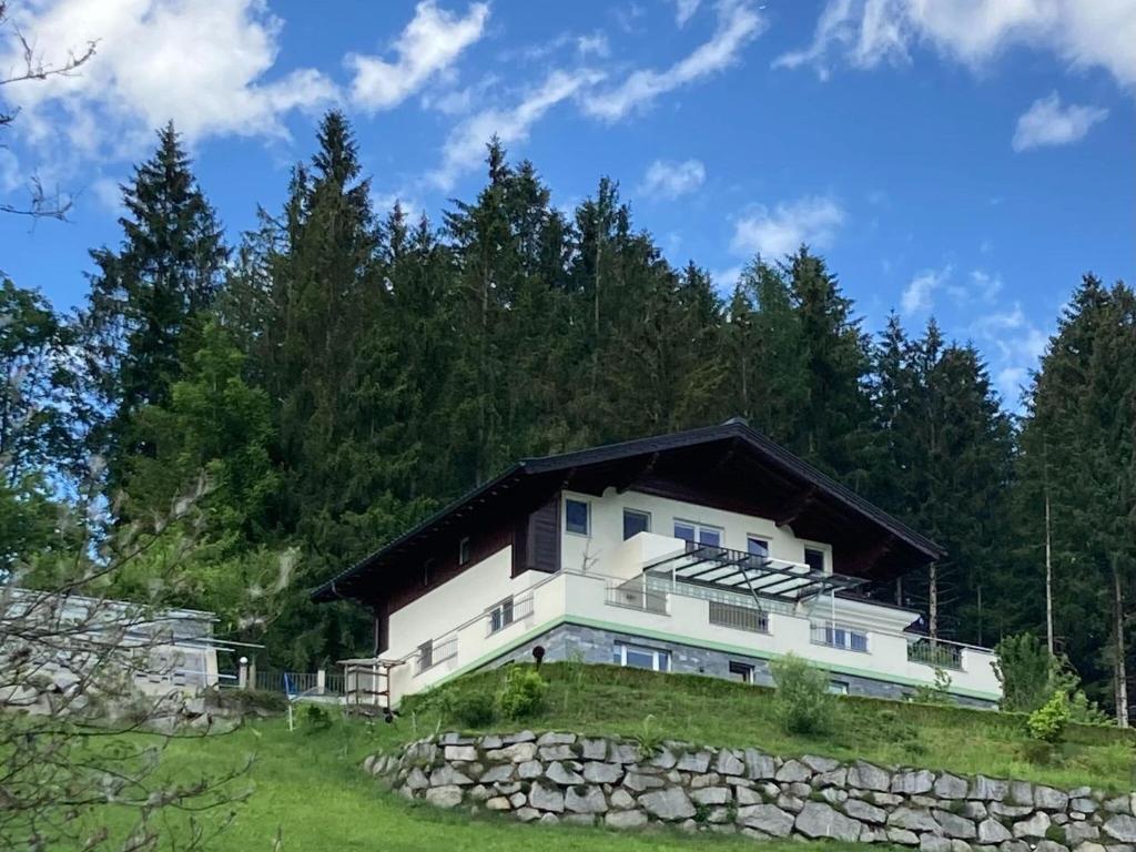 uma casa numa colina com uma parede de pedra em Holiday apartment in Pinzgau with a large terrace em Mittersill