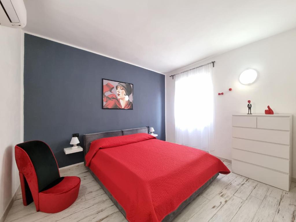una camera con un letto rosso e una sedia rossa di Solino House a Capoliveri