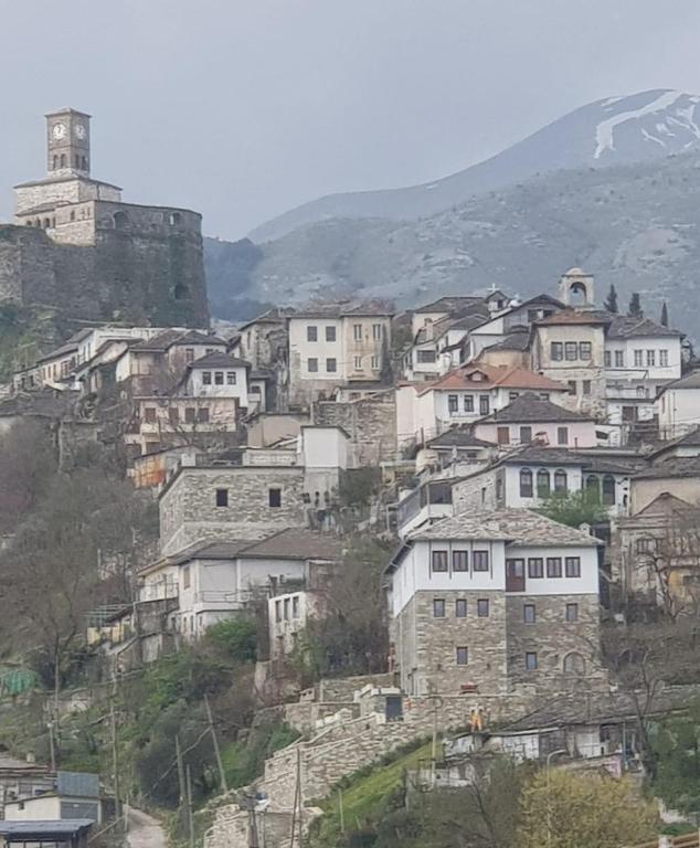 Un mucchio di case su una collina con una torre di The Stone Sky Hotel a Gjirokastër