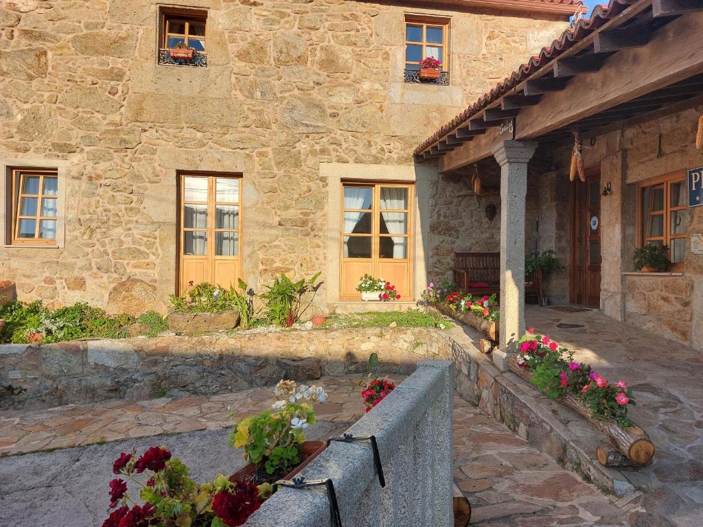 a stone house with flowers in front of it at Casa Luz in Lires