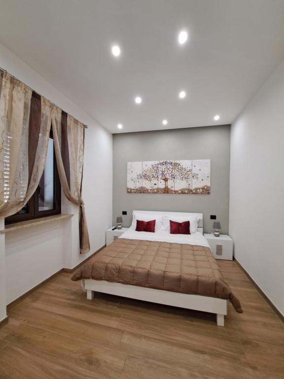 um quarto branco com uma cama grande e almofadas vermelhas em Colle del Re Sicily em Partinico