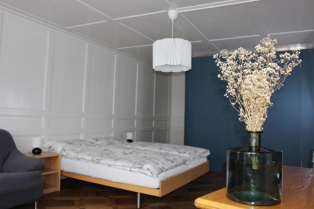 1 dormitorio con 1 cama y un jarrón de flores sobre una mesa en Hotel Jäger, en Murten