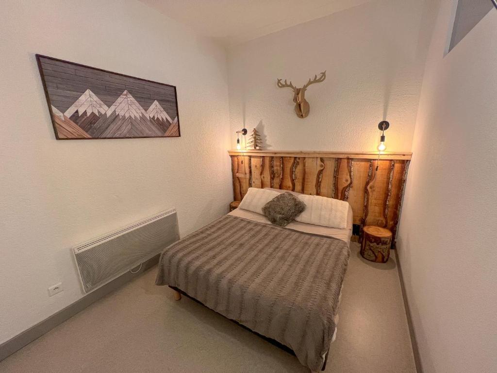 a small bedroom with a bed and a picture on the wall at Le repère du Cerf T2 Résidence Royal Milan ST Lary Soulan in Saint-Lary-Soulan