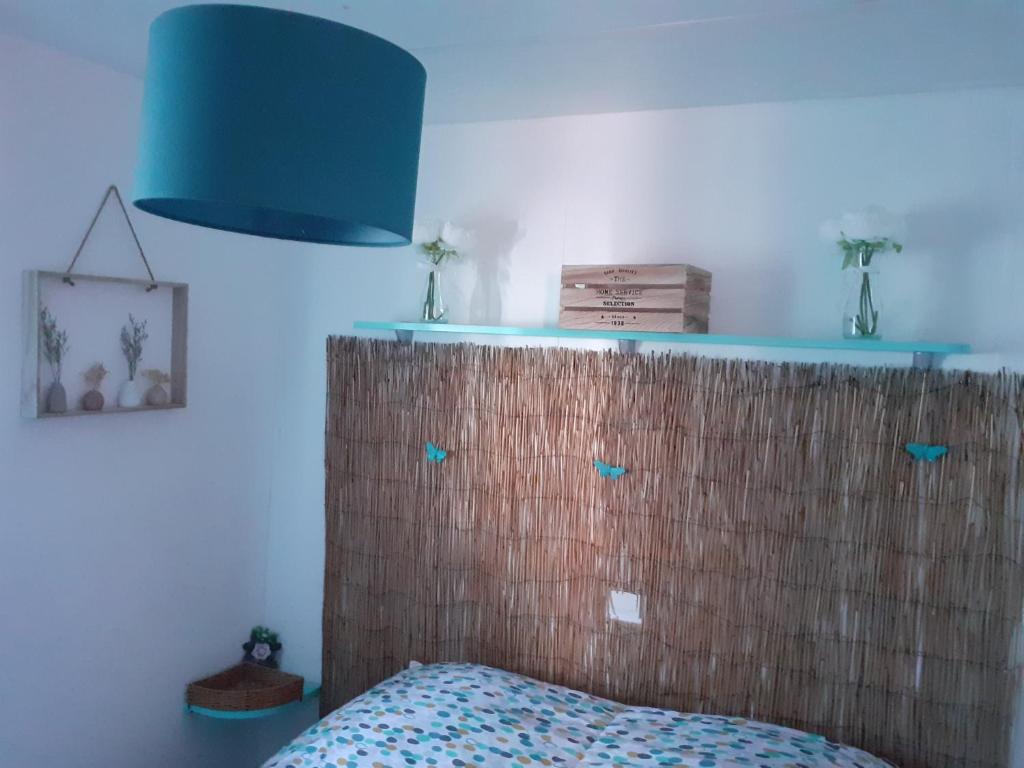 a bedroom with a headboard and a blue lamp at les cigales in Vic-la-Gardiole