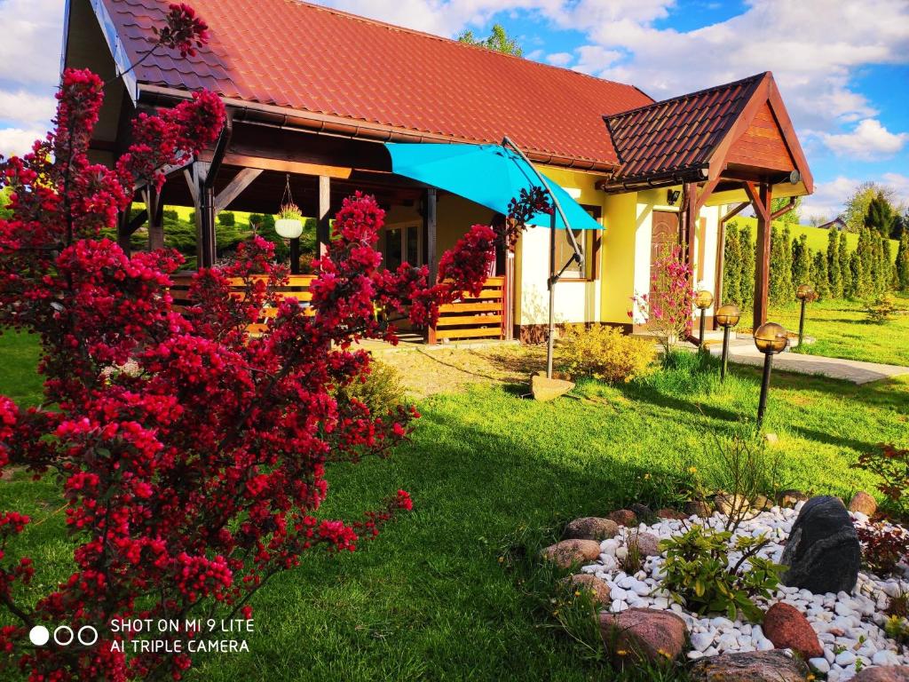 エウクにあるWczasyMazurskie - Domek " Lawenda" Mazuryの庭の赤い花の家