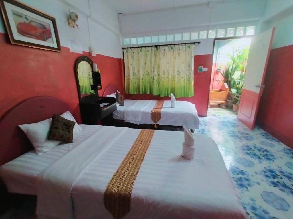 two beds in a room with red walls at Sabaydee House at Pai in Pai