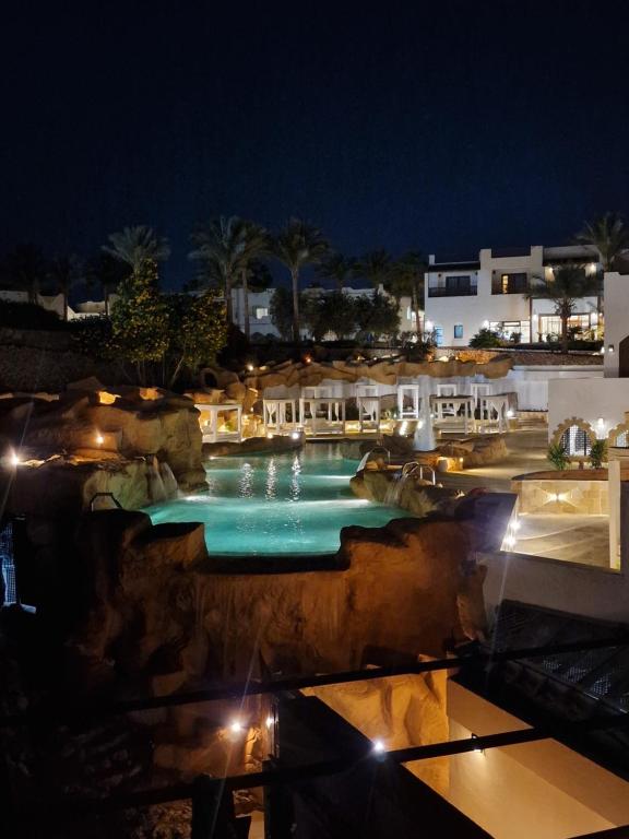ein Schwimmbad in der Nacht mit Lichtern in der Unterkunft Domina Coral Bey Harem in Sharm El Sheikh