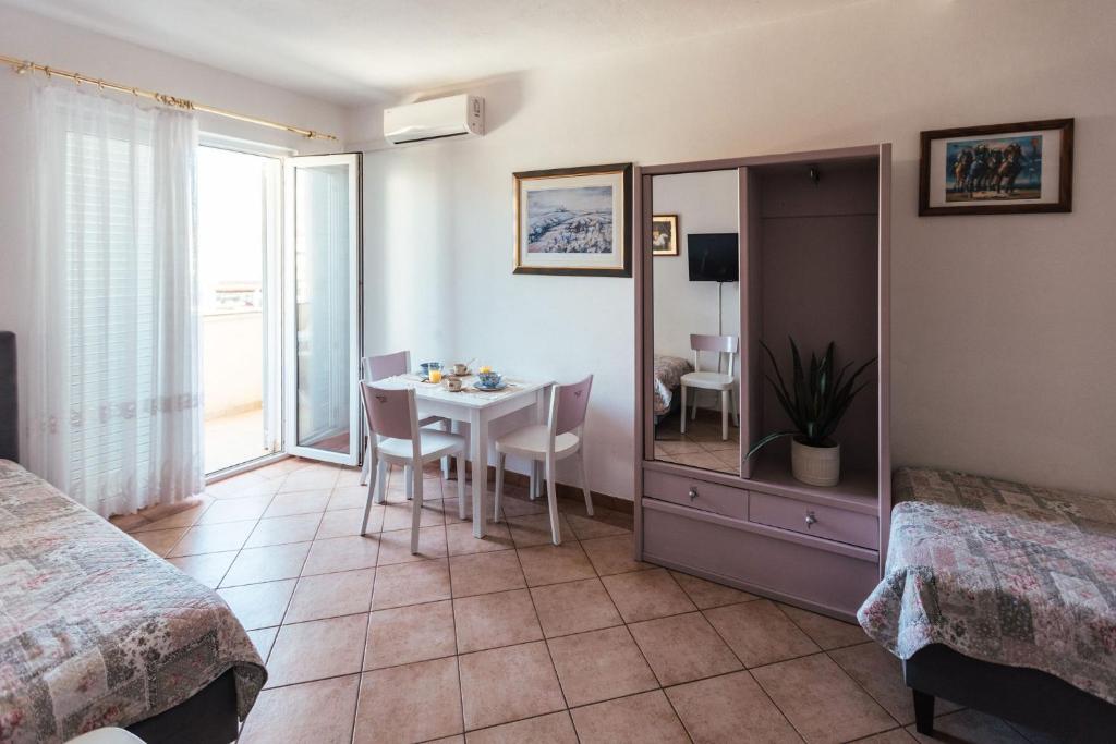 une chambre d'hôtel avec une table et un miroir dans l'établissement Villa Porta, à Biograd na Moru