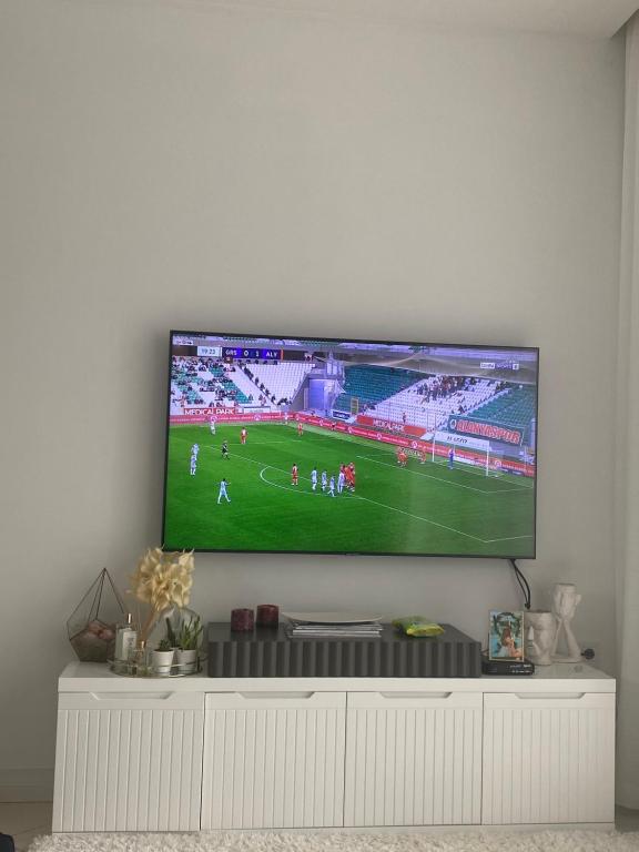 una televisione su un muro con una partita di calcio di Konforlu,keyifli. a Emin Sitesi