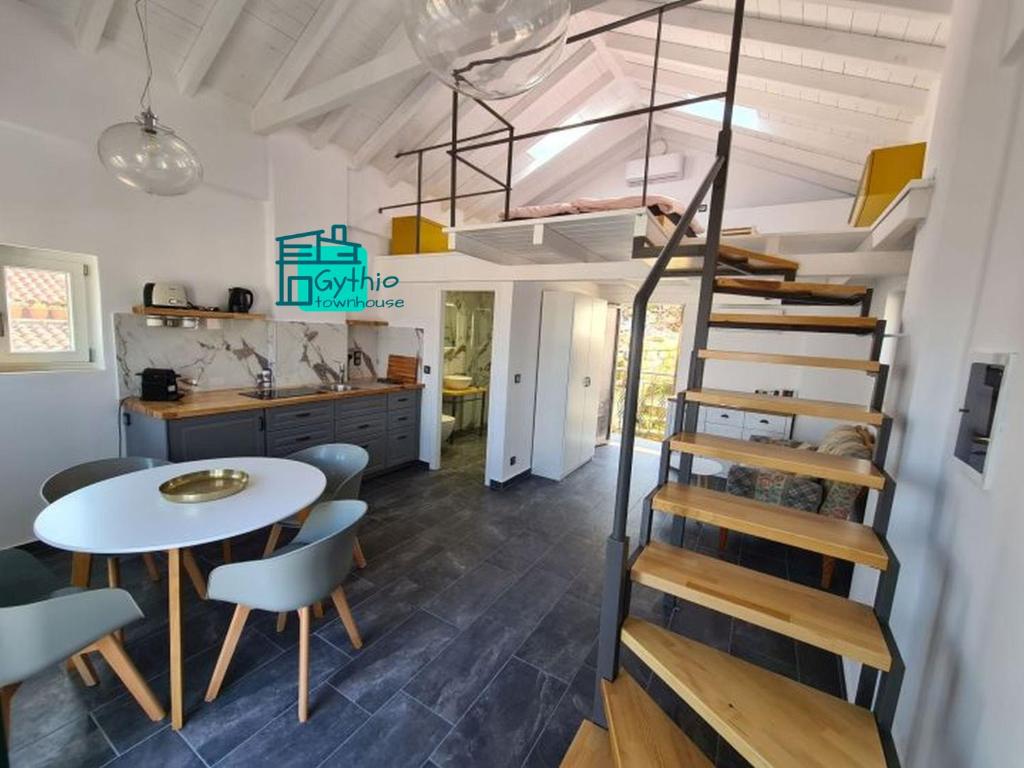 a room with a spiral staircase and a table and chairs at Gythio townhouse in Gythio