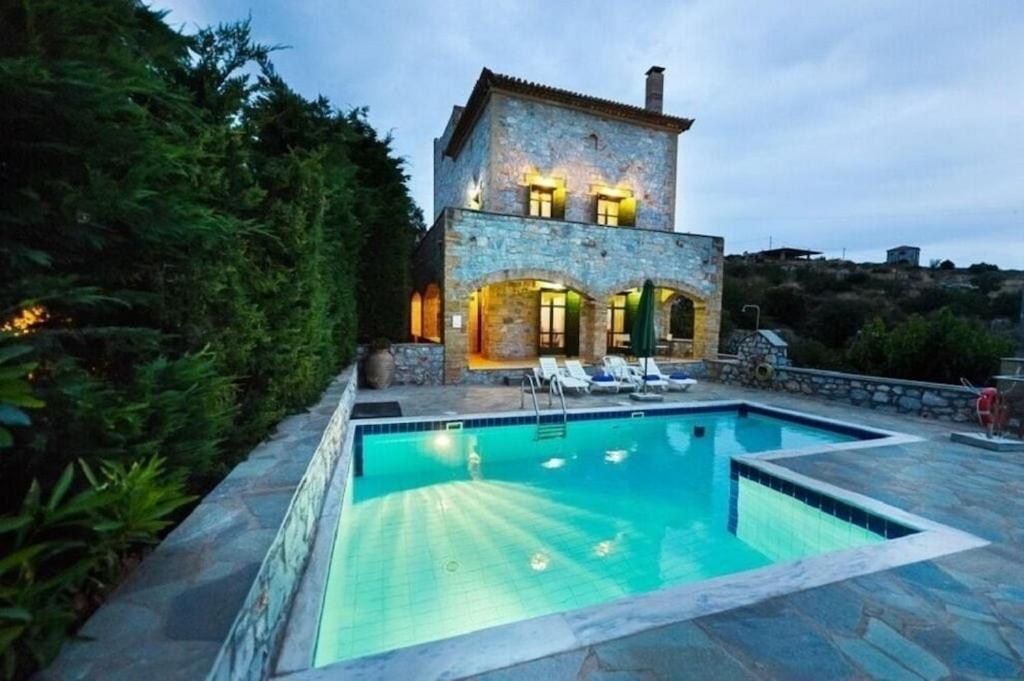 ストウパにあるSOFIA, Luxury Stone Villa in Stoupa with Private Pool, BBQ and Amazing Sea Viewの家の前にプールがある家