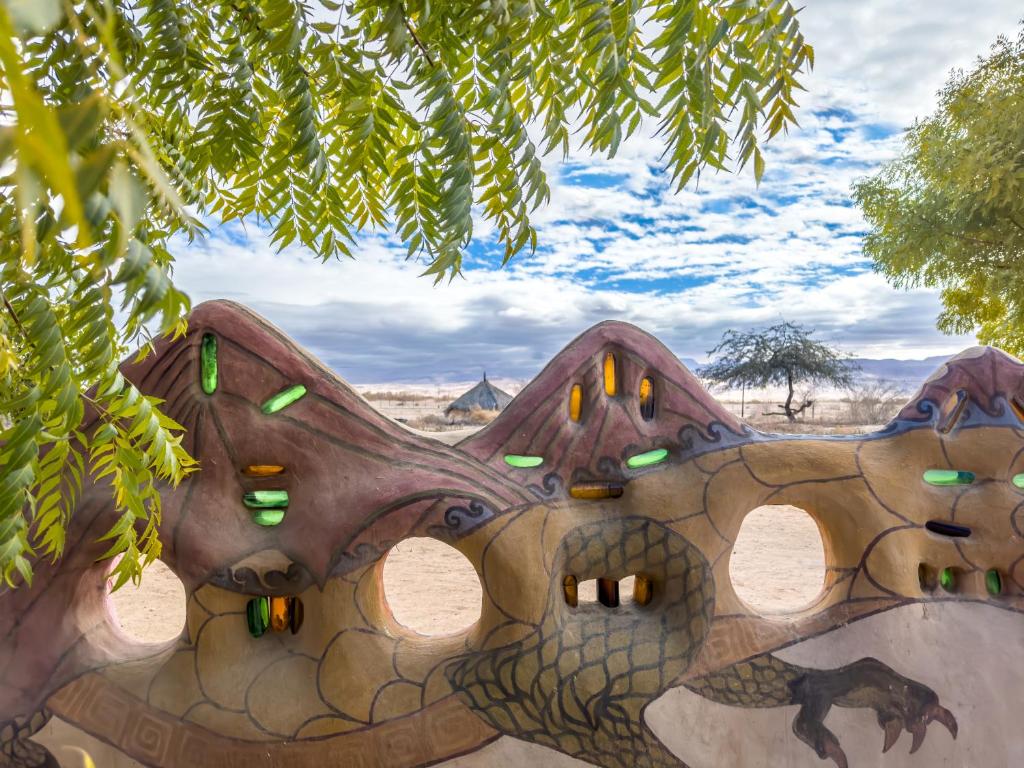 een schilderij van een stenen gebouw met groene lichten bij Lotan Desert Travel Hotel in Naẖal Ya‘alon