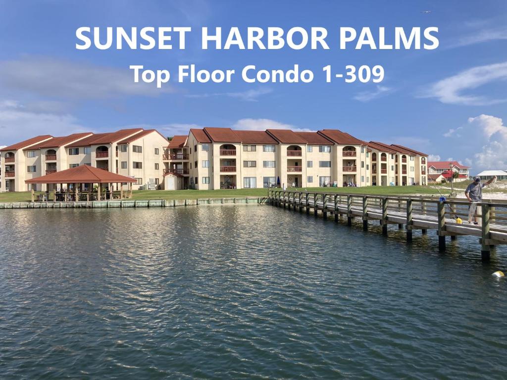 a view of aominium building from the water with a dock at Sunset Harbor Condo for 2-TOP FLOOR 1-309, Navarre Beach in Navarre