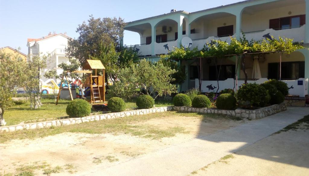 a house with a garden in front of it at Apartman M&M in Lopar
