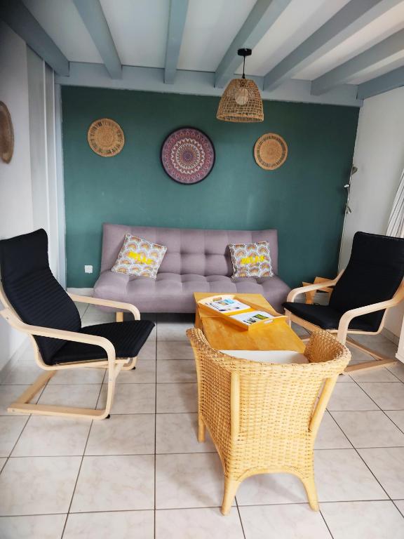 un salon avec un canapé, une table et des chaises dans l'établissement MAISON LANDES OCEAN, à Saint-Julien-en-Born