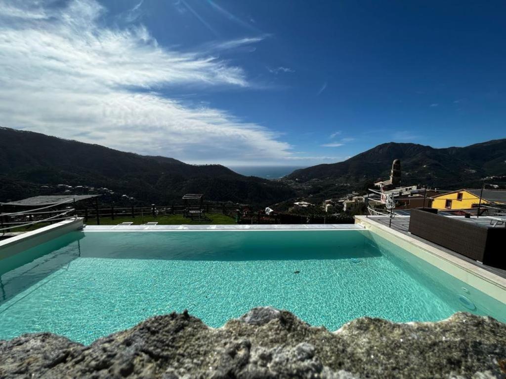 a large swimming pool on top of a building with mountains at Angiolina's Farm in Levanto