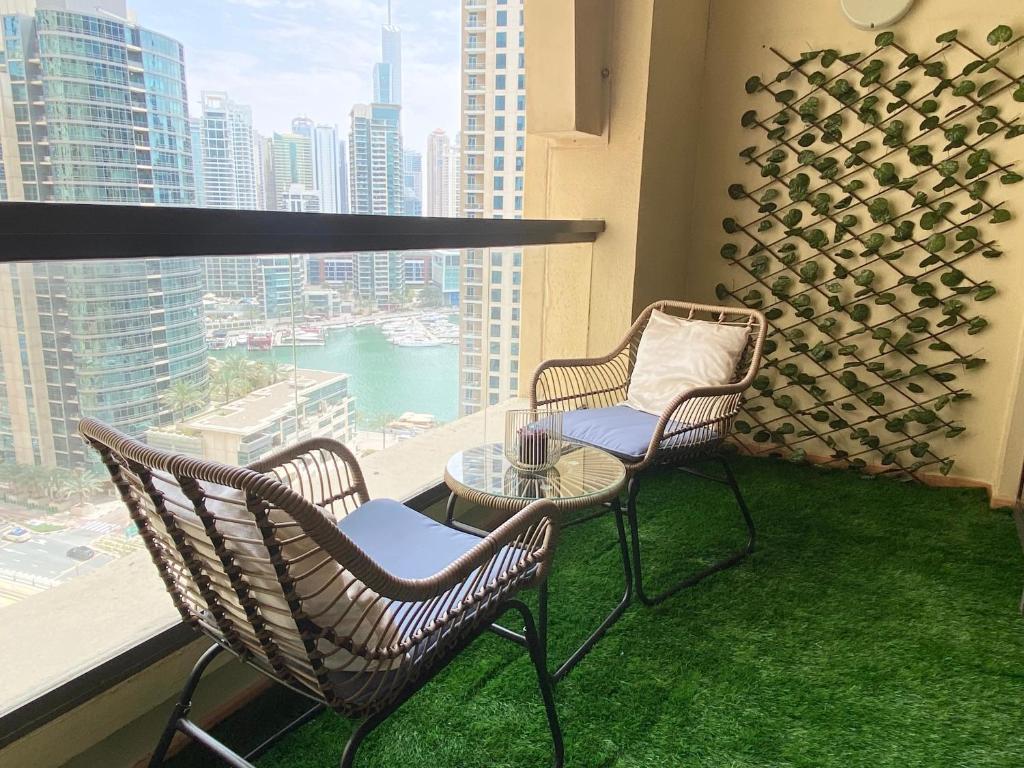 Duas cadeiras e uma mesa numa varanda com vista em Charming spacious studio apartment in the heart of JBR By SWEET HOMES em Dubai