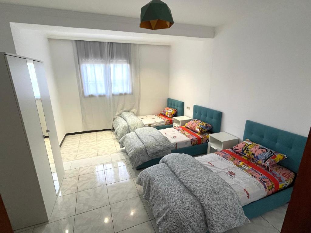 a small room with two beds and a window at Apart familiar bab okla in Tétouan